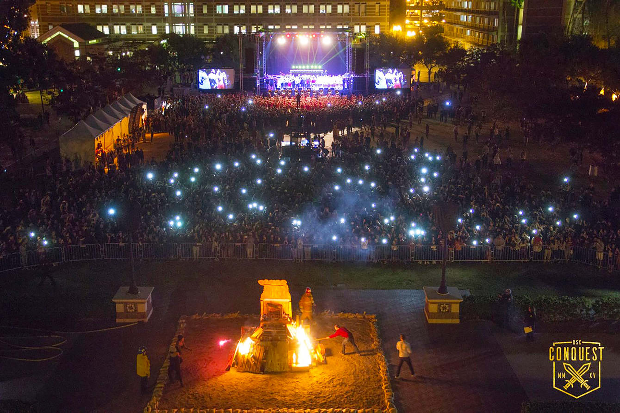 Crowd of thousands viewing the stage with a bonfire in the background